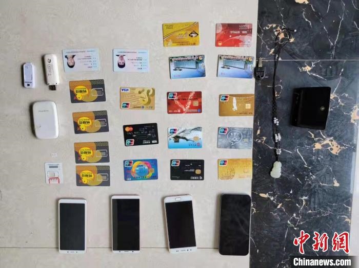資料圖為果洛藏族自治州公安民警查扣的作案手機(jī)和涉案銀行卡?！‖斍呖h公安局供圖