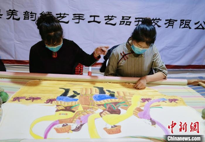 圖為皮繡藝人在市集上“秀”指尖技藝?！●R銘言 攝