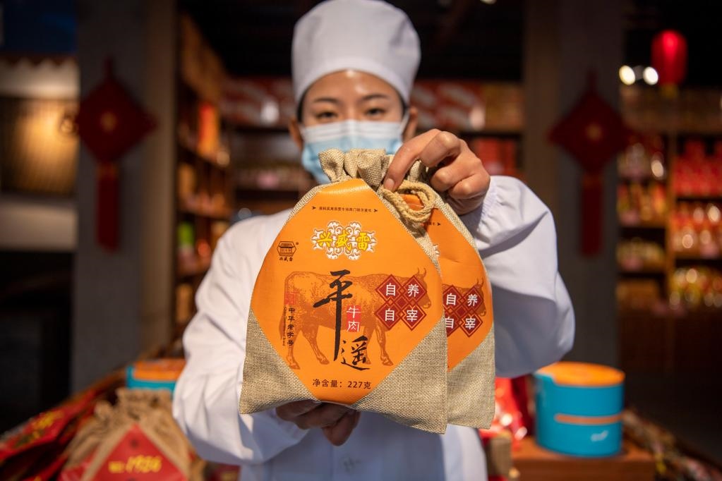 1月27日，在平遙古城南大街的一家平遙牛肉店內(nèi)，工作人員展示一款牛肉產(chǎn)品。新華社記者 楊晨光 攝