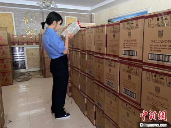 資料圖為檢察人員核對查獲的假冒品牌白酒。青海省人民檢察院供圖