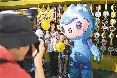 5月7日，在浙江省杭州市湖濱步行街“3D笑臉墻”前，攝影師為游客與杭州亞運(yùn)會吉祥物之一“宸宸”拍攝合影。
