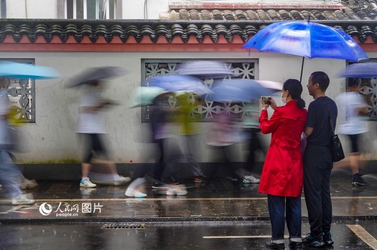 6月7日，在浙江省2023年普通高校招生考試鎮(zhèn)海中學(xué)考點，家長冒雨目送子女進(jìn)入考場。人民網(wǎng) 章勇濤攝