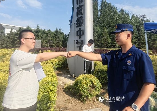 6月7日，遼寧營口老邊區(qū)消防救援大隊的消防員為高考學(xué)子加油助威。人民網(wǎng)記者 尹柏寒?dāng)z