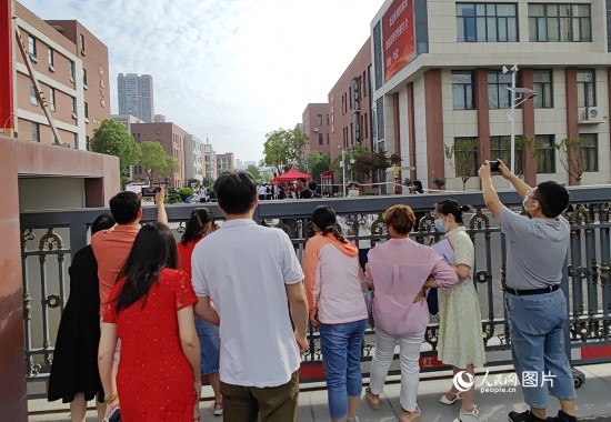 6月7日，武漢市第三中學(xué)考點，考生進(jìn)場后，家長在柵欄外用手機(jī)拍攝自己的孩子。人民網(wǎng)記者 郭婷婷攝