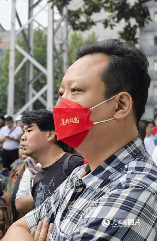 6月7日早，在武漢市第二十六中學(xué)考點外，送考家長戴著印有“金榜題名”的口罩。人民網(wǎng) 周雯攝