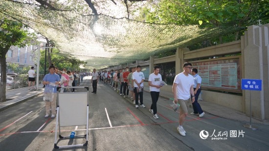 6月7日，烏魯木齊市第七十中學(xué)門口，考生們有序進(jìn)入考場。人民網(wǎng) 李欣洋攝