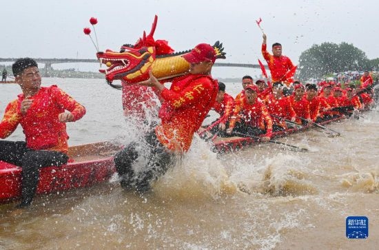 6月22日，在湖南省岳陽(yáng)市湘陰縣湘江臨資口水域，參加龍舟賽的隊(duì)員接“龍頭”下水。
