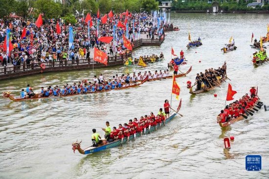 6月23日，在貴州省黔東南苗族侗族自治州施秉縣舉行的獨(dú)木龍舟節(jié)上，獨(dú)木龍舟進(jìn)行水上巡游。