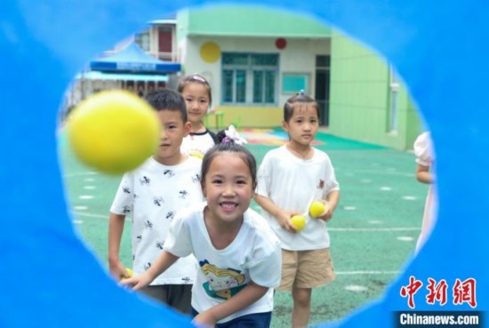 在肥西縣山南鎮(zhèn)中心幼兒園，孩子們在玩布洞投球游戲。陳家樂 攝