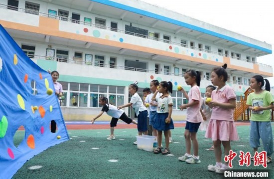 在肥西縣山南鎮(zhèn)中心幼兒園，孩子們在玩布洞投球游戲。陳家樂 攝