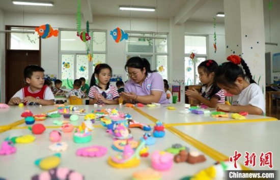 在肥西縣山南鎮(zhèn)中心幼兒園，孩子們在老師的指導(dǎo)下做彩色泥塑。陳家樂 攝