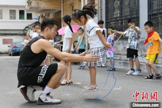 圖為大學生志愿者在教孩子們學跳繩。廖光福 攝