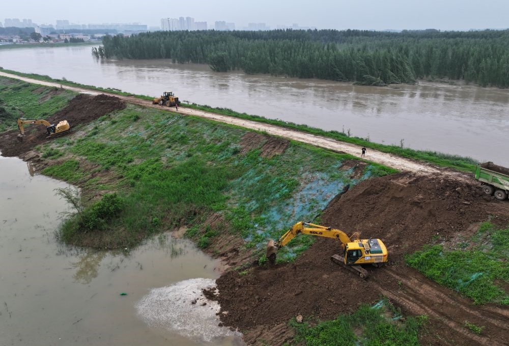 工人操作機械在白溝河左堤白溝新城高橋村段進行除險加固作業(yè)（8月4日攝，無人機照片）。新華社記者 朱旭東 攝