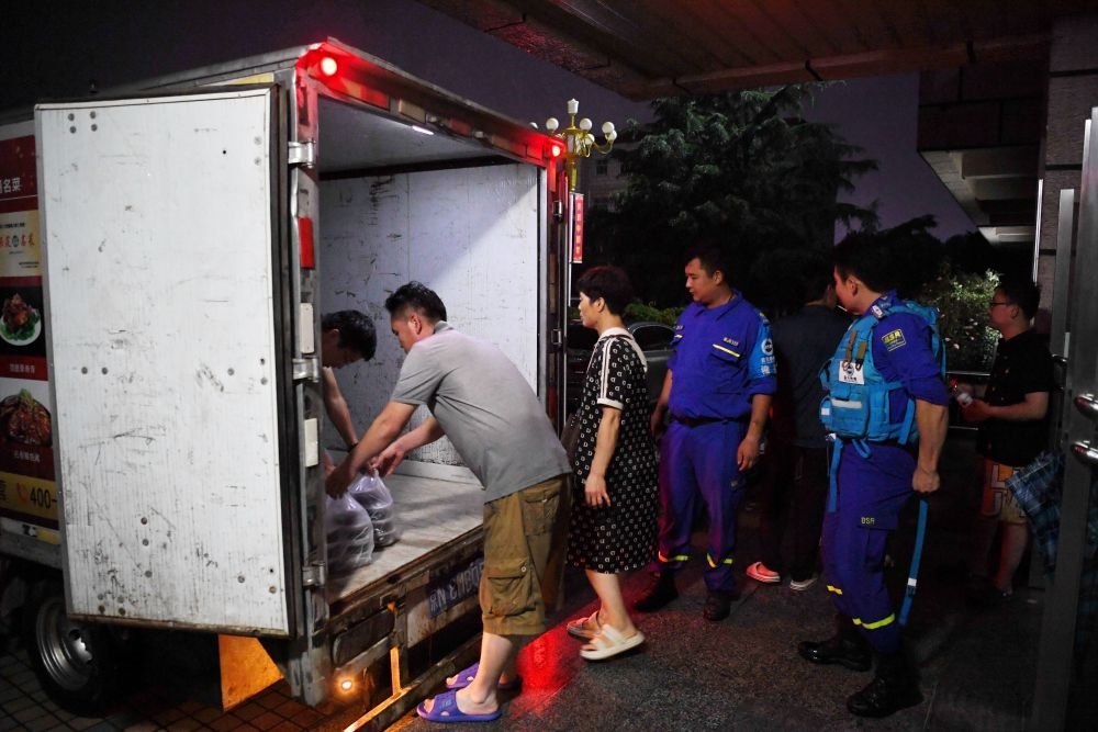 河北省涿州市職教中心安置點的工作人員在運送飯菜，準備發(fā)放給安置群眾（8月1日攝）。新華社記者 牟宇 攝