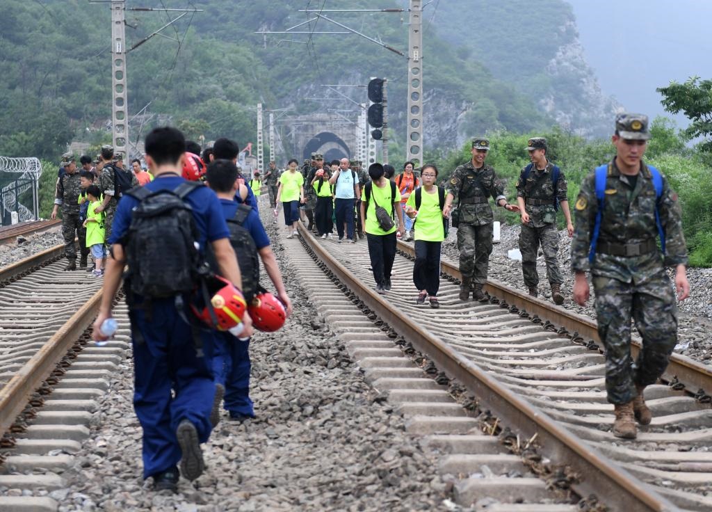 8月2日，部分滯留在北京市門頭溝山區(qū)受困列車的旅客，在救援人員幫助下前往轉(zhuǎn)運(yùn)客車。新華社記者張晨霖 攝