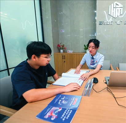 在杭州市臨安區(qū)政務(wù)服務(wù)中心的“為企服務(wù)中心”，黨員志愿者（右）解答企業(yè)主的疑問（2023年7月7日攝）。徐昱攝/本刊