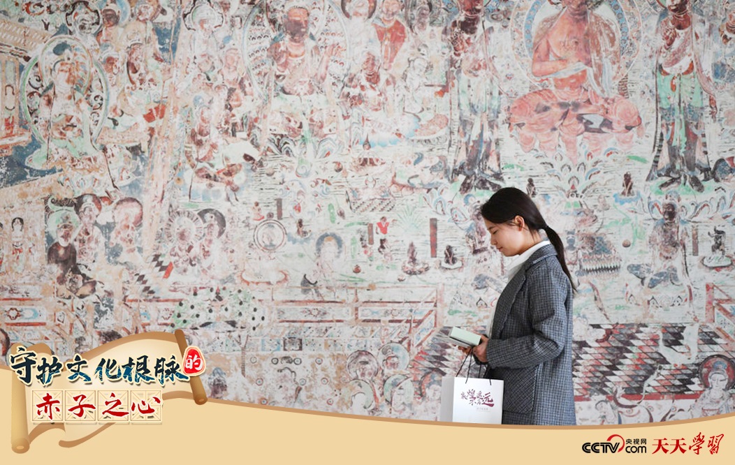 2023年4月25日，敦煌研究院文物數(shù)字化保護團隊創(chuàng)意營銷人員廖雪婷從一幅高保真復制壁畫前走過。