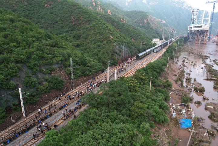 8月2日，受困列車旅客在救援人員幫助下徒步趕往轉(zhuǎn)運(yùn)客車（無人機(jī)照片）。新華社記者 張晨霖 攝