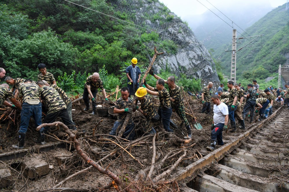 8月1日，在北京市門頭溝區(qū)水峪嘴村附近一段被阻斷的鐵路線上，中鐵六局工作人員在清理軌道上的雜物，全力恢復(fù)交通。新華社記者 鞠煥宗 攝