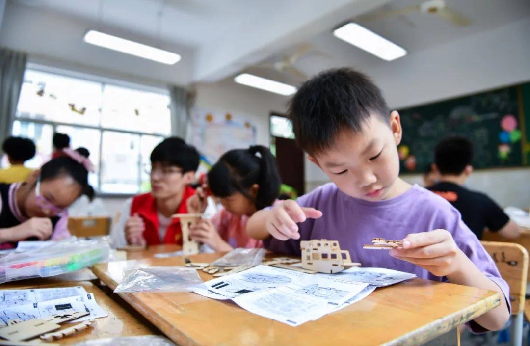 △今年7月，在浙江余姚市舜北小學(xué)暑托班內(nèi)，孩子們制作太陽能科學(xué)實驗裝置。