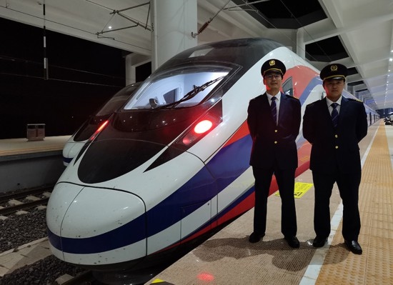 劉銀能（右一）與中國師父鄔俊鴻在動車組前合影。受訪者供圖