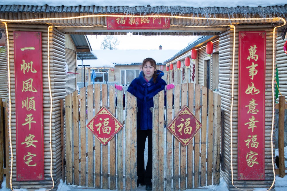 北極村民宿經(jīng)營(yíng)者史瑞娟在門(mén)前迎候入住的游客（2023年1月7日攝）。