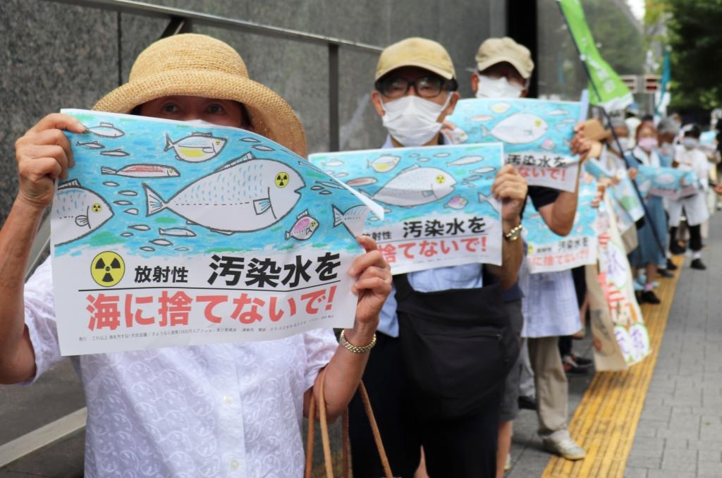8月24日，日本民眾手持“不要將污染水扔進(jìn)大?！钡葮?biāo)語在東京電力公司總部前集會(huì)，抗議日本政府和東電公司無視民意啟動(dòng)核污染水排海。新華社記者楊光攝