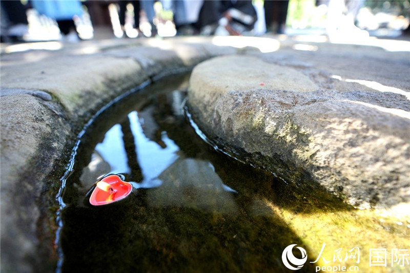 圖為水渠里流過(guò)的“桃心”蠟燭。人民網(wǎng) 盧鵬宇攝