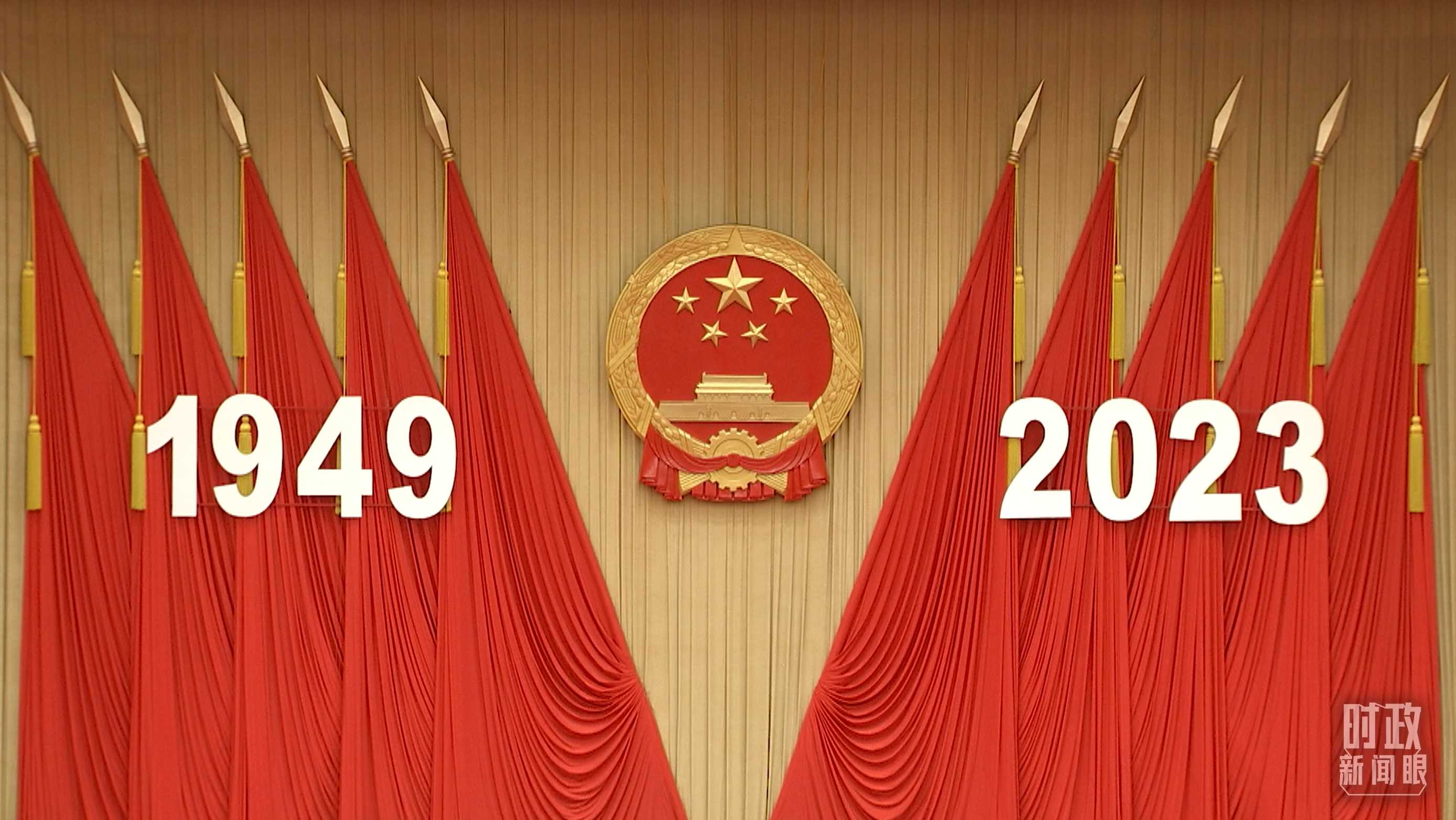 △人民大會堂宴會廳內(nèi)，主席臺上方高懸著莊嚴的國徽，“1949－2023”大字年號在鮮艷的紅旗映襯下格外醒目。
