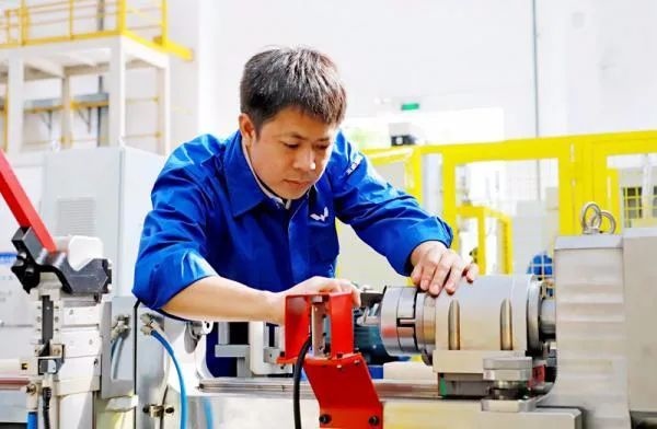△鄭志明正在對襯套自動壓裝設(shè)備進行檢測調(diào)試。