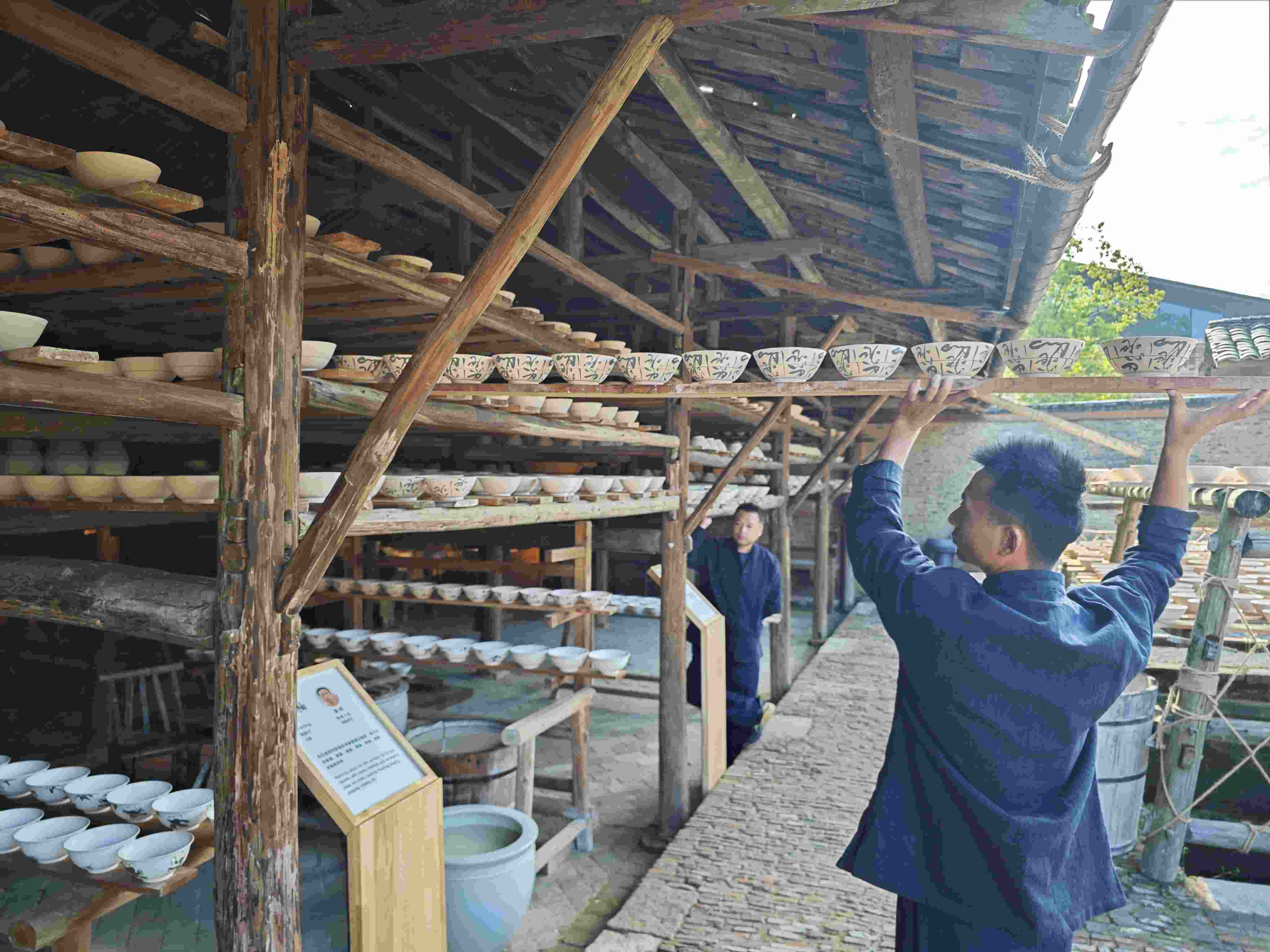 △陶陽(yáng)里歷史文化街區(qū)里，工匠將陶瓷工藝品放到架上晾干。（總臺(tái)央視記者彭漢明拍攝）