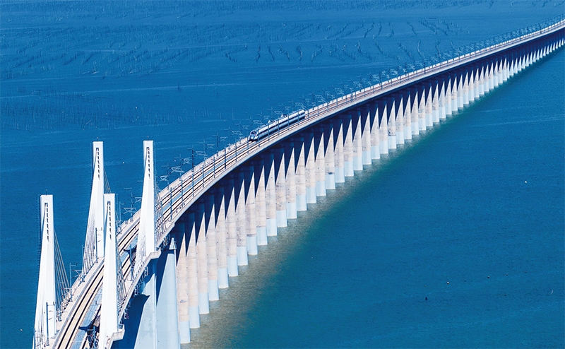 2023年9月28日，中國首條時速350公里跨海高鐵——福廈高鐵正式開通運營。圖為一列運行試驗車組駛過福廈高鐵湄洲灣跨海大橋（9月19日攝，無人機照片）。 新華社記者 魏培全/攝