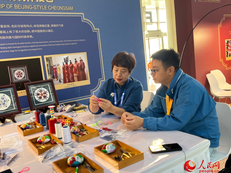 記者在新聞中心非遺傳承人展區(qū)進(jìn)行體驗(yàn)。人民網(wǎng)記者 杜燕飛攝