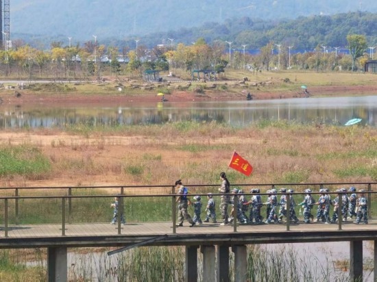 10月24日，秋游的幼兒園小朋友在老師帶領(lǐng)下走在清水塘公園里的木橋上。本報記者 常雯宜攝