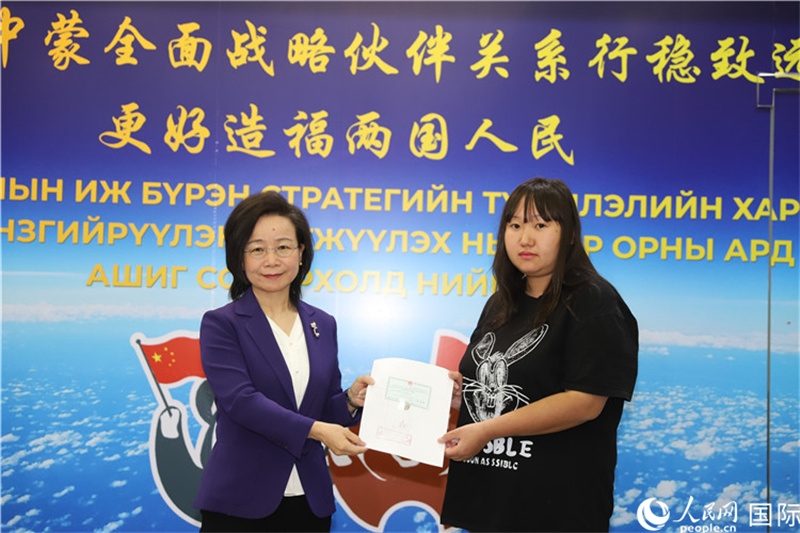 11月10日，沈敏娟大使向蒙古國(guó)公民尼亞姆庫(kù)（右）頒發(fā)最后一份領(lǐng)事認(rèn)證書。人民網(wǎng)記者 霍文攝