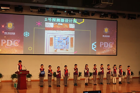 北京呼家樓中心小學的學生們展示PDC項目“新行星移民計劃探索衛(wèi)星設計”。