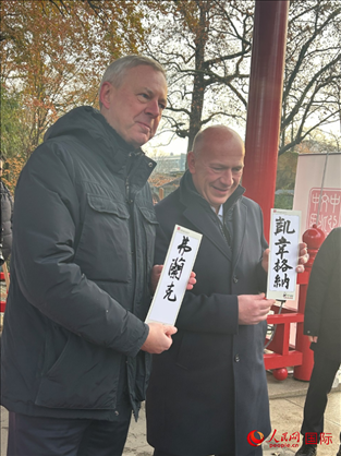 柏林市長(zhǎng)韋格納（右）、動(dòng)物園監(jiān)事會(huì)主席布魯克曼（左）手持中國(guó)文化中心工作人員現(xiàn)場(chǎng)手書的中文名字。人民網(wǎng)記者 徐馨攝