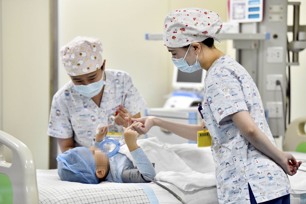 在山東省棗莊市婦幼保健院兒童ICU病房，醫(yī)護(hù)人員為完成靶向治療藥物諾西那生鈉的4歲脊髓性肌萎縮癥患兒加油鼓勁（2022年1月1日攝）。諾西那生鈉注射液是我國(guó)首個(gè)獲批治療脊髓性肌萎縮癥的進(jìn)口藥物，2019年進(jìn)入中國(guó)市場(chǎng)時(shí)，每針價(jià)格近70萬(wàn)元。在2021年國(guó)家醫(yī)保目錄藥品談判中，以3.3萬(wàn)元每針的價(jià)格進(jìn)入新版醫(yī)保藥品目錄。新華社記者 郭緒雷 攝