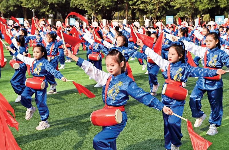 為助推民族地區(qū)基礎(chǔ)教育事業(yè)發(fā)展，廣西重新核定各地中小學(xué)教職工編制，依托全區(qū)編制“周轉(zhuǎn)池”核增事業(yè)編制給各地中小學(xué)，在全面達(dá)到國(guó)家標(biāo)準(zhǔn)的基礎(chǔ)上，進(jìn)一步統(tǒng)籌優(yōu)化和動(dòng)態(tài)調(diào)整各區(qū)域、學(xué)校、學(xué)段間編制資源。圖為2023年11月29日，南寧市濱湖路小學(xué)舉行主題為“逐夢(mèng)新時(shí)代 健體向未來(lái)”的體育文化節(jié)，孩子們正在跳腰鼓舞。 新華社記者 周華/攝