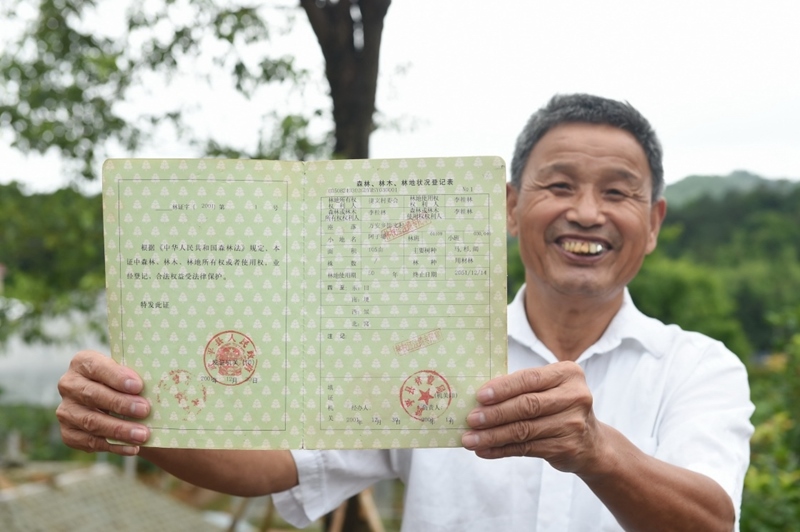 福建武平縣萬(wàn)安鎮(zhèn)捷文村村民李桂林展示林權(quán)改革后領(lǐng)到的全國(guó)第一本新式林權(quán)證。