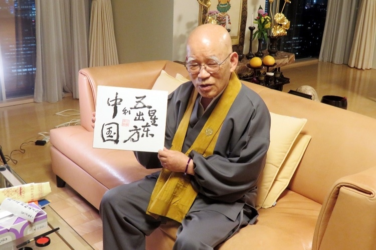 小島康譽展示自己書寫的“五星出東方利中國”。視頻截圖