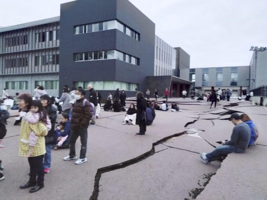  1月1日，在日本石川縣輪島市，人們站在被地震破壞的地面上。新華社/共同社