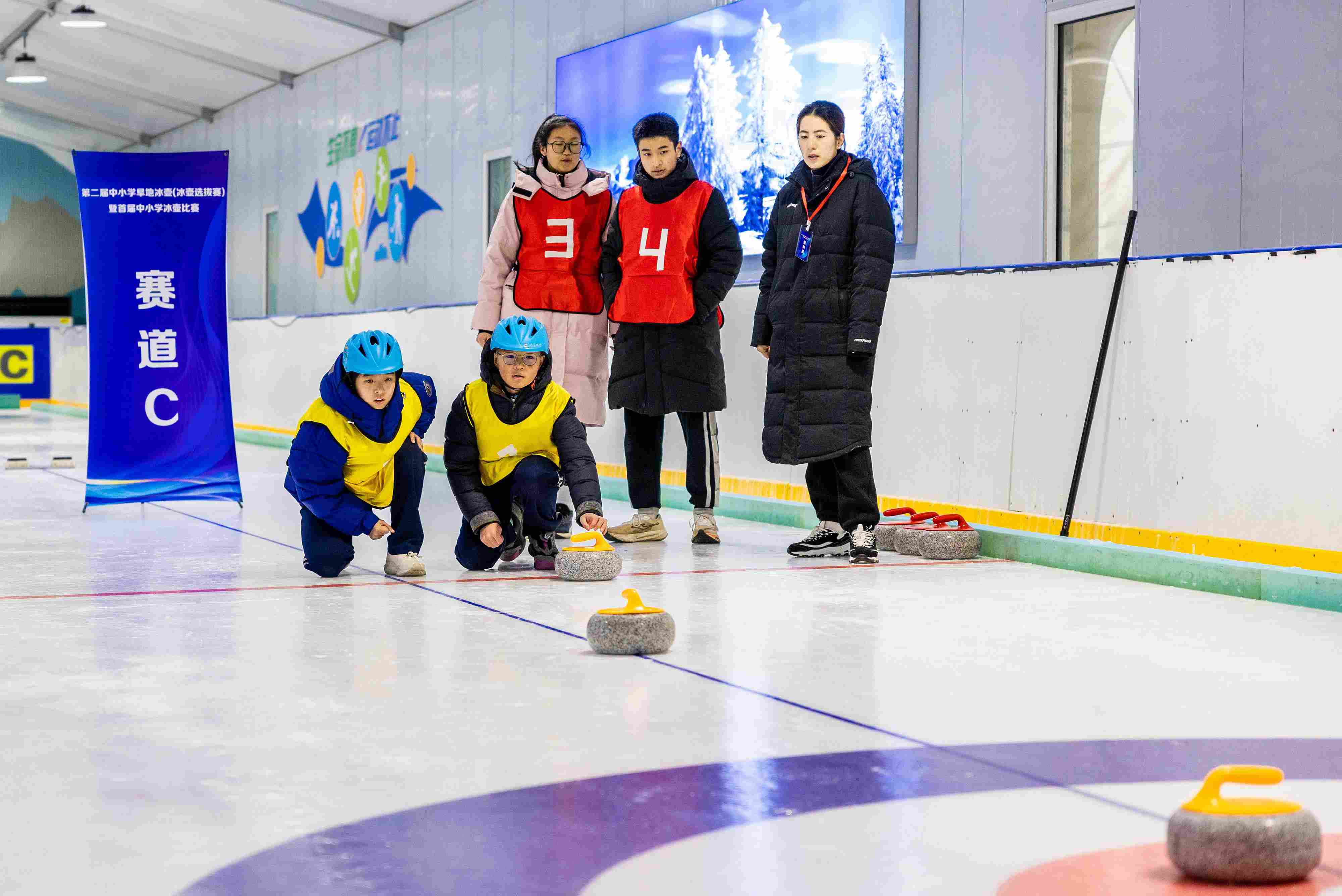 2023年12月10日，參賽選手在呼和浩特首屆中小學(xué)冰壺比賽中投擲冰壺。