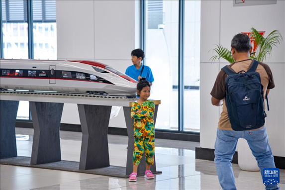 1月24日，在印度尼西亞雅加達(dá)哈利姆站候車大廳，一名小朋友和雅萬高鐵高速動(dòng)車組模型合影。新華社記者 徐欽 攝