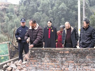  圖③：庭審結(jié)束后，在法官的見(jiàn)證下，陳某在院壩邊重新開(kāi)鑿一條通道。