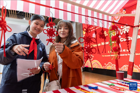 1月28日，復(fù)旦大學(xué)第二附屬學(xué)校學(xué)生（左）為美國(guó)馬斯卡廷中學(xué)學(xué)生（右）介紹中國(guó)結(jié)。 新華社記者 王翔 攝