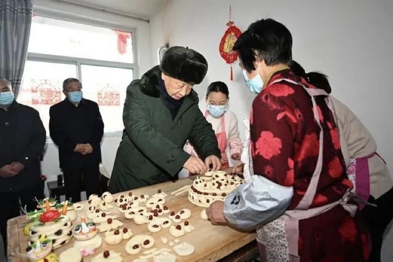 2022年1月26日，習近平總書記在山西省臨汾市霍州市師莊鄉(xiāng)馮南垣村，同師紅兵一家做年饃。新華社記者 李學仁 攝
