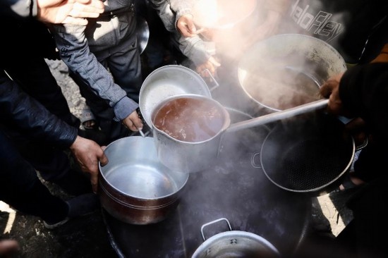  2月27日，在加沙地帶北部的杰巴利耶難民營，人們領(lǐng)取食物。新華社發(fā)（穆罕默德·阿里攝）