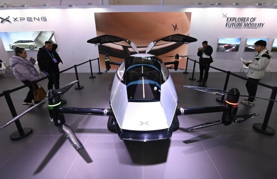 2023年12月1日，在鏈博會智能汽車鏈展區(qū)小鵬汽車展臺，參觀者觀看一臺智能飛行器。新華社記者蔡湘鑫攝
