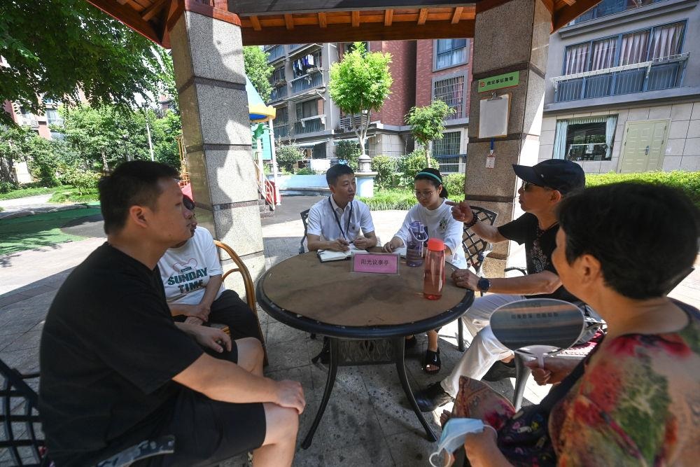 △2023年7月21日，在位于浙江杭州臨安區(qū)錦南街道水岸陽光小區(qū)的陽光議事廳，街道干部在聽取居民們反映的問題及意見。